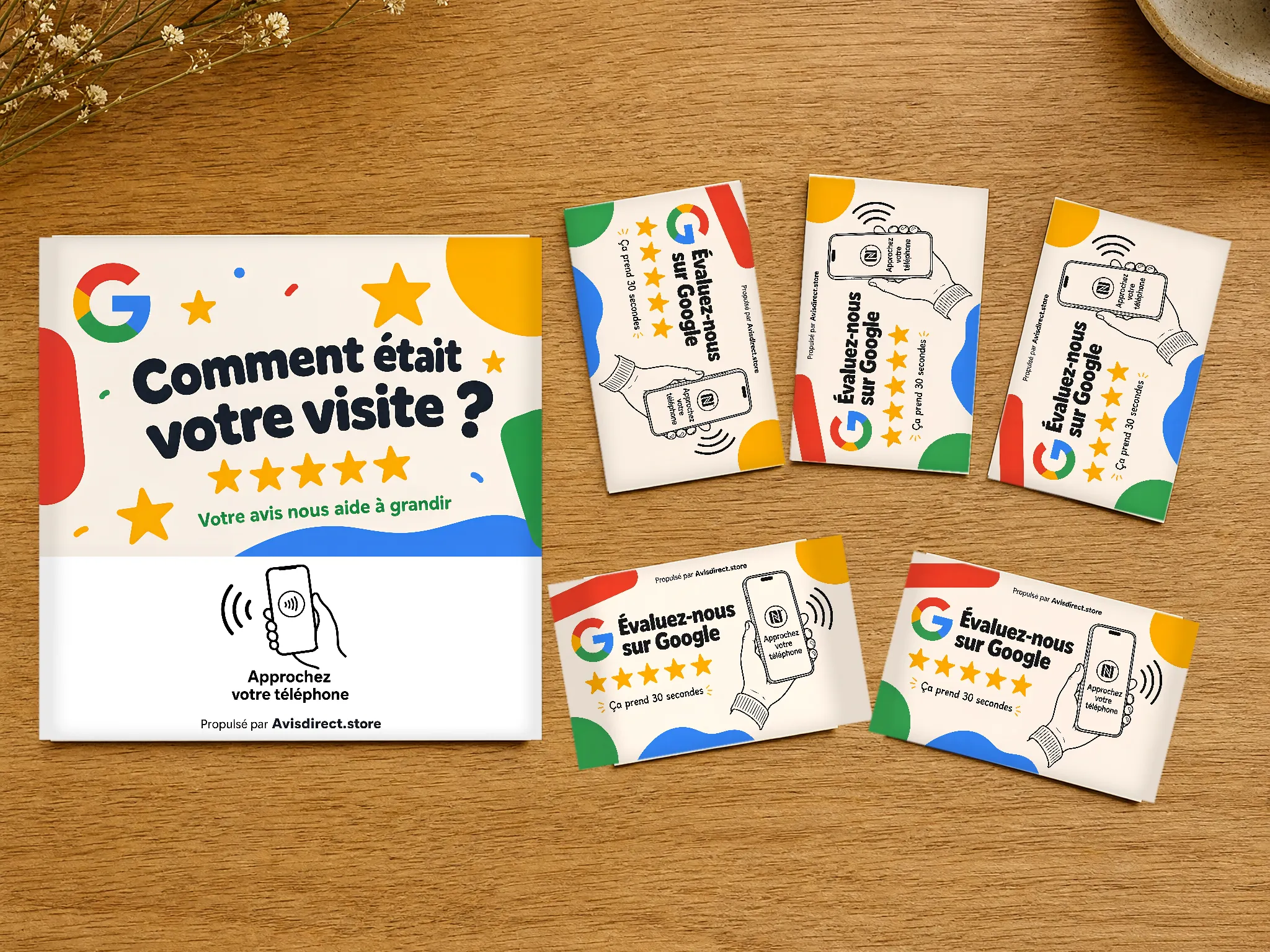 Le Pack Complet Avisdirect : la grande carte comptoir et les 5 cartes format carte de visite, posées à plat sur un comptoir en bois
